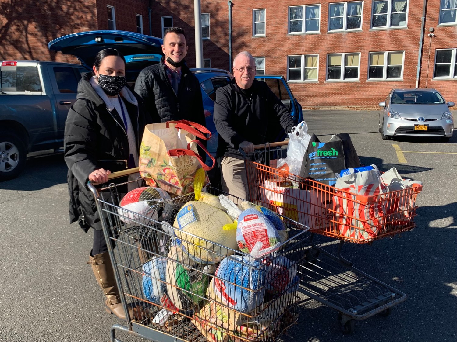 High School  faculty pushed shopping carts full of food to the donation drop-off site.